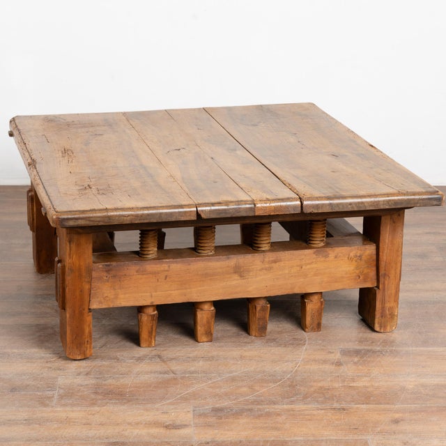 20th century rustic square coffee table from Hungary. The base is uniquely constructed using old vice elements, creating...