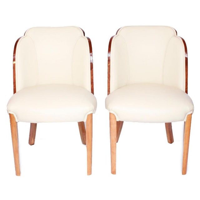 A pair of art deco cloud back chairs, re-upholstered in cream leather and alcantara suede. Dimensions: h 83cm, w 52cm,...