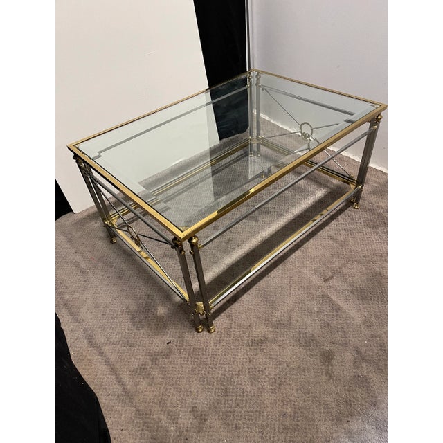 Mid century modern neoclassical style chrome and brass coffee table. Made in Italy in the 1970s. There is an inset glass...