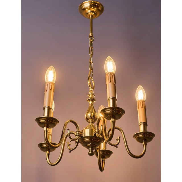 Stylish brass chandelier with five arms in a classic historic style. The structure is made of polished brass with...