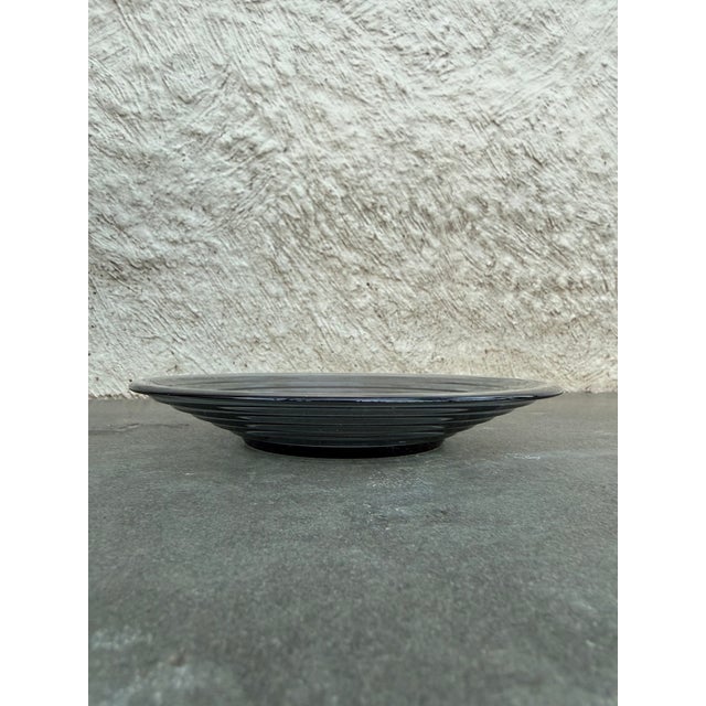 Set of four gray glass plates with a circular stepped motif. Designed by Aino Aalto for iittala, Finland. All the plates...