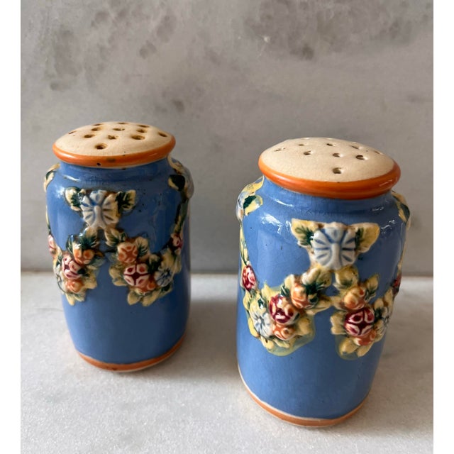 Set of hand painted cornflower blue salt and pepper shakers with swags of raised red, orange, and blue flowers. Original...