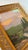 Vibrant acrylic landscape painting on canvas, depicting a flowing river at the base of majestic mountains and pines. A...