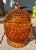 Footed amber art glass lidded candy jar featuring raised hobnail pattern. Lovely vintage piece with a beautiful rich and...
