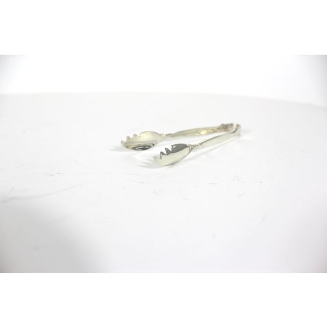 Small vintage silver plated sugar tongs with lobster claw tips. These are made by Rogers Bros 1956 in the Flair pattern....