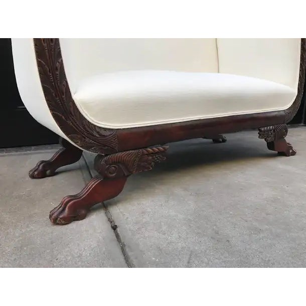 The deep seated and high-backed early nineteenth century upholstered scroll end sofa, having a show-frame with concave...