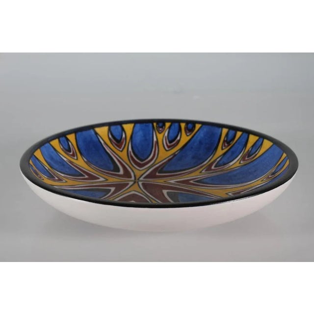 Large low ceramic bowl by Søholm Denmark. This bowl has a graphic pattern in bright colors of blue, yellow, brown and...