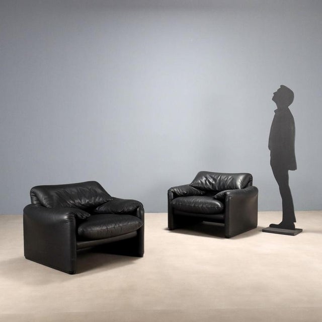 Pair of armchairs with foam padding and black leather upholstery. The backrest features a fold-down headrest, "allowing...
