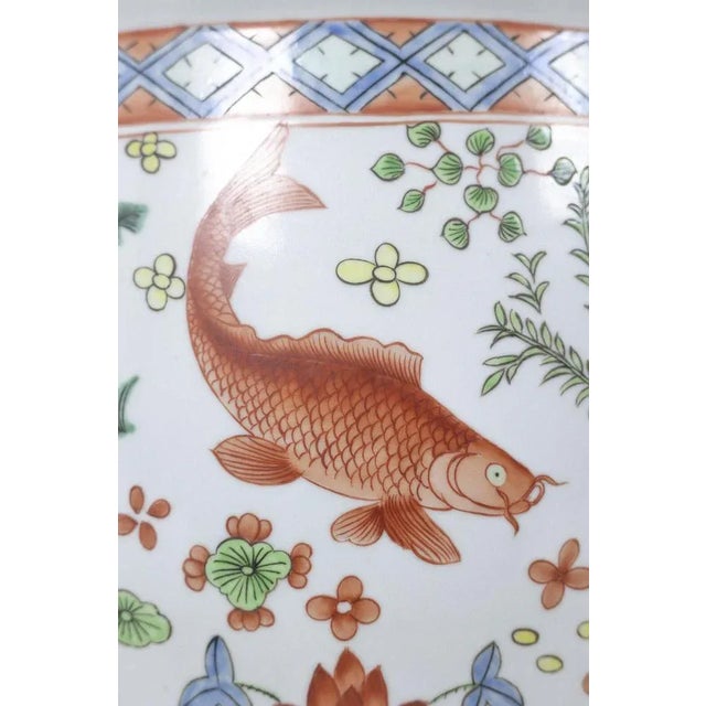 Pair of Canton porcelain planters, circular in shape, decorated with koi carp. Work realized circa 1950. This piece is...