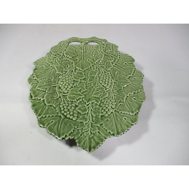 A vintage green footed serving bowl with handle, decorated with raised leaves and grapes. It was made in Portugal by Olfaire.