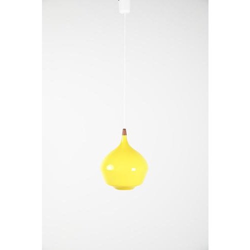Holmegaard pendant made of bright yellow colored glass with a beautiful teak wooden detail. This detail is not original...
