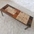 Low rectangular table with a brushed iron frame and a top made of handcrafted tiles, alternating between "Herbier"...