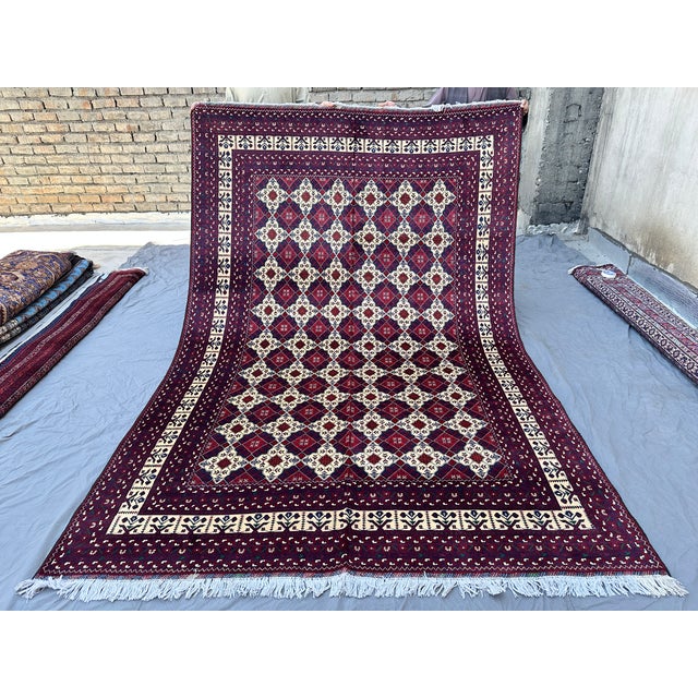 This richly detailed Khal Mohammadi rug features a dense diamond lattice in crisp ivory, filled with delicate floral and...