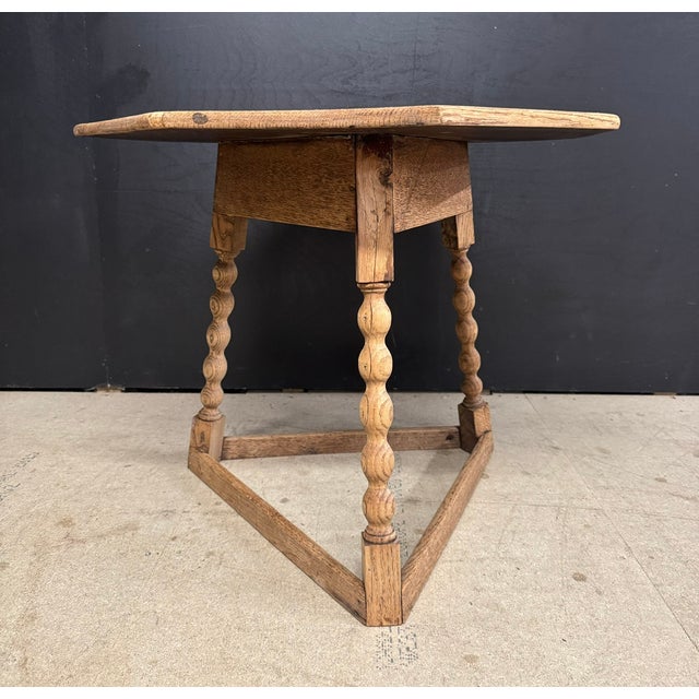 A delightful English oak cricket table, having a crisply carved octagonal top and fine bobbin turned legs. We have lightly...