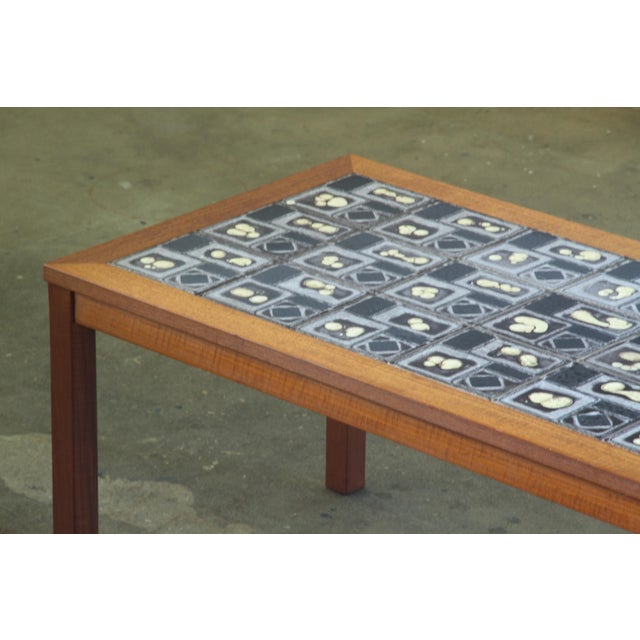 This Danish teak coffee table, adorned with exquisite ceramic tiles, is an ideal addition for post-dinner gatherings. The...