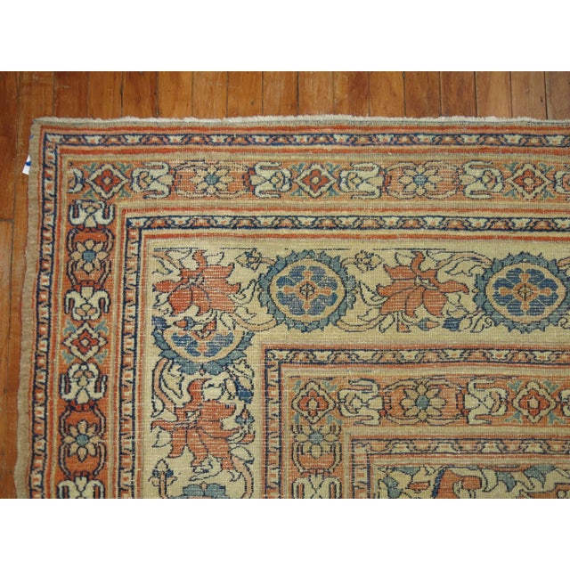 A lovely antique Persian doroksh rug featuring accents of soft blue and burnt orange set on an open camel ground, circa...
