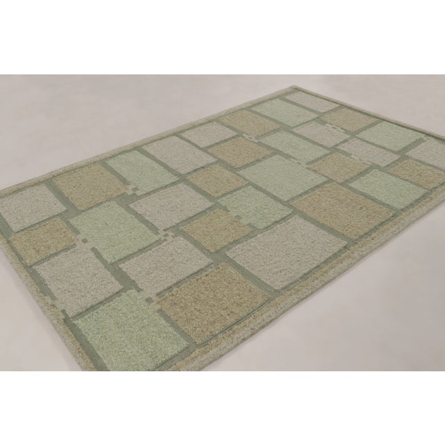 This 6x9 Scandinavian kilim showcases a geometric mosaic pattern in sage green, beige, and silver-gray tones. Representing...