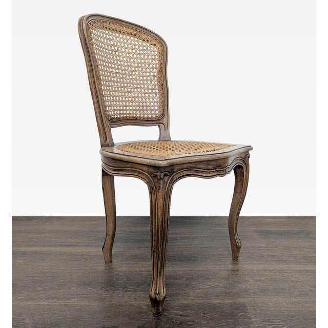 Wood carved chair with cane back and seat. Dimensions (in): 19W x 18D x 36H.