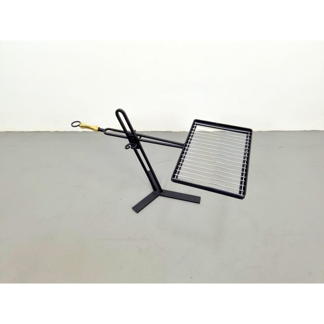 Vintage, authentic adjustable barbecue grill grate, 1950 An adjustable, black-lacquered metal grill grate on an open stand...