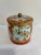 A vibrant vintage Daher canister with a rich orange and gilt chinoiserie design. White reserves frame delicate blossoms...