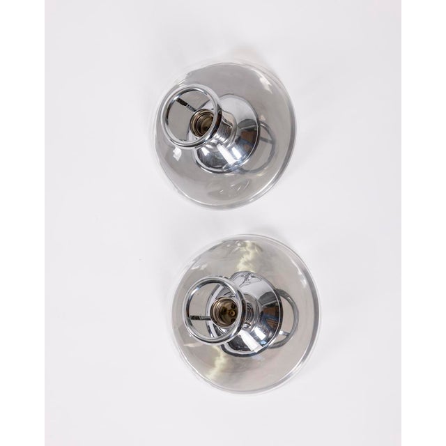 Pair of wall lamps with chromed metal frame and transparent hemispherical glass, Italian design, 1980s. Up to 250V...