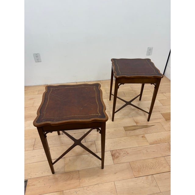 Elegant Georgian Revival nightstands crafted in rich mahogany, each topped with an original leather surface featuring gilt...