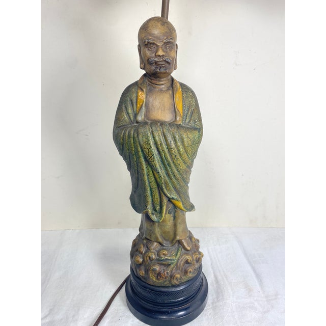 Single lamp from the 1940s featuring Monk in robe on top of two tier wood base. The lamp is solid and heavy plaster. The...