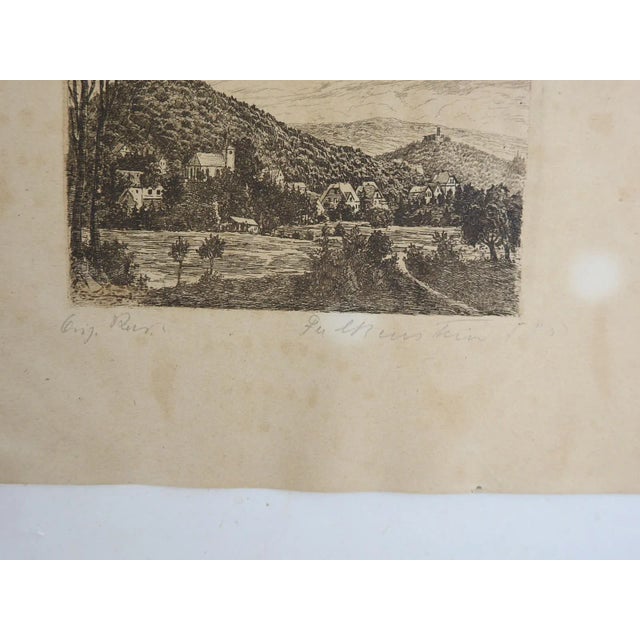 Small early 20th century etching on tan paper of european castle and village along river. Signed illegibly in pencil along...