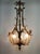 Bronze and brass chandelier decorated with reeds and flowers from which six lights radiate, three molded glass shells...