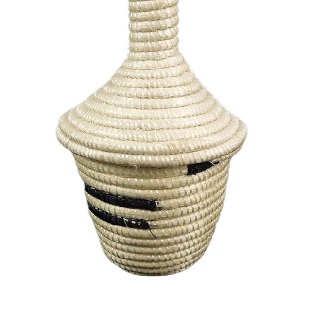 The Tutsi Tight Weave Basket with Lid from Rwanda epitomizes the artistry and tradition of the Tutsi community's weaving...