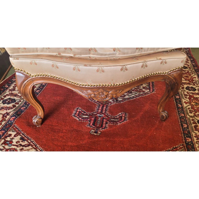 Fine French style carved wing chair with bumblebee fabric. Features ornate French victorian style carved walnut frame,...