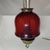 Antique hanging oil lamp features a striking ruby red glass hobnail-style shade and ornate brass-tone metal hardware. The...