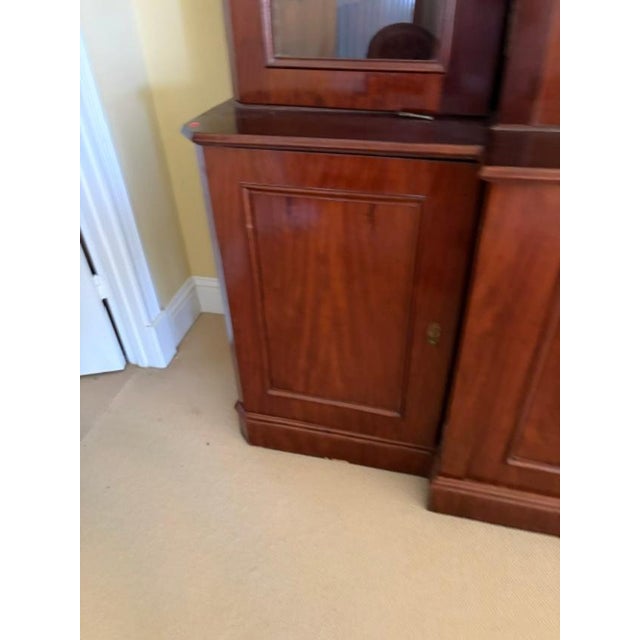This antique English mahogany three door breakfront bookcase from circa 1850 is a stunning piece of furniture. Standing at...