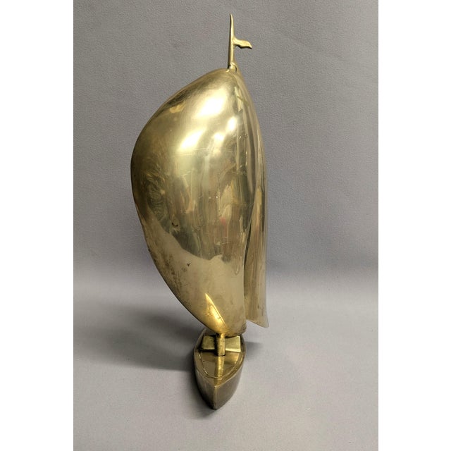 A mid-century vintage brass sailboat complete with a top flag. The solid brass sailboat is unique as it has billowing...
