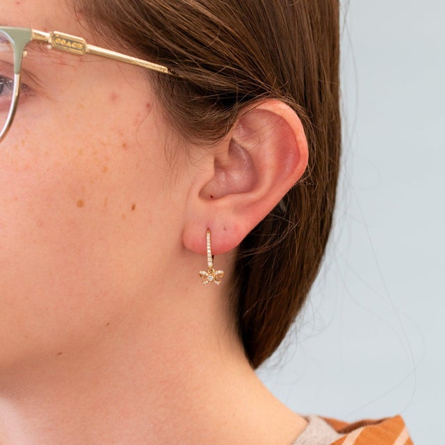 Delicate bows shimmer with natural diamonds in these leverback earrings, crafted in solid 14K yellow gold. Feminine and...