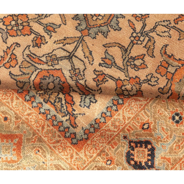 An early 20th century Sultanabad rug from West Persia, the tan field with a palmette and flowering vine trellis overall...