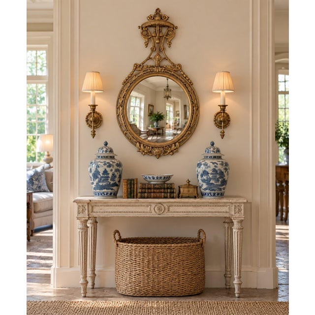 A beautifully proportioned mid-20th century convex wall mirror in the Robert Adam style, featuring a classic giltwood...