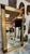 Striking oversized Mid-Century Modern wall mirror featuring a richly textured gilt frame with sculptural walnut corner...