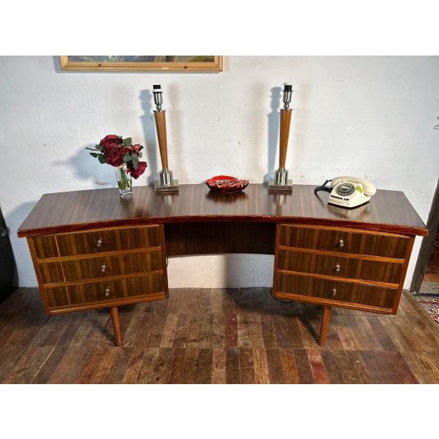 A simple and elegant but stunning walnut and teak desk from the early mid century. This desk has a curved design and made...