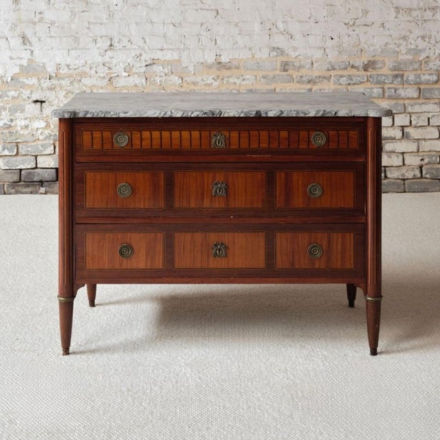 Add refined neoclassical elegance to your space with this French Louis XVI period marble top commode, circa 1770, a superb...