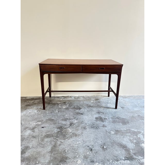 Danish Desk from the 1950s Made of teak, the desk features two drawers with recessed handles.