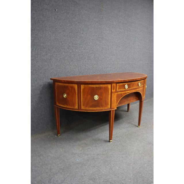 Baker Furniture Williamsburg Collection sideboard with inlay detail and banded top. Features a bowed front, center drawer...