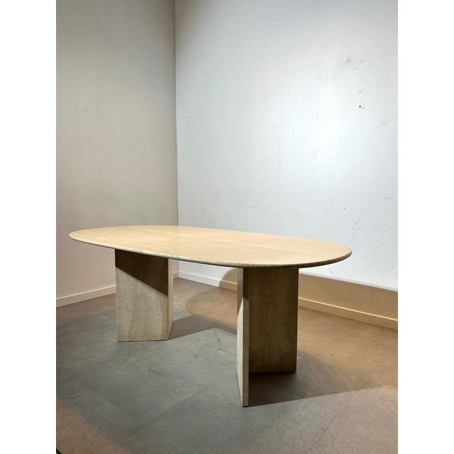 This elegant vintage dining table is crafted entirely from natural travertine, featuring an oval top with beautiful...