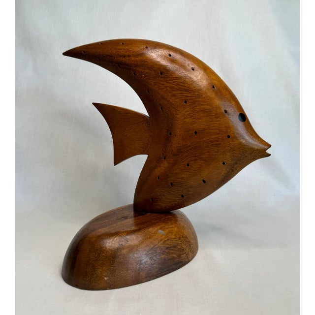 The clean lines and shape enhance this solid wood sculpture of an Angelfish. With painted eyes and drilled holes on the...