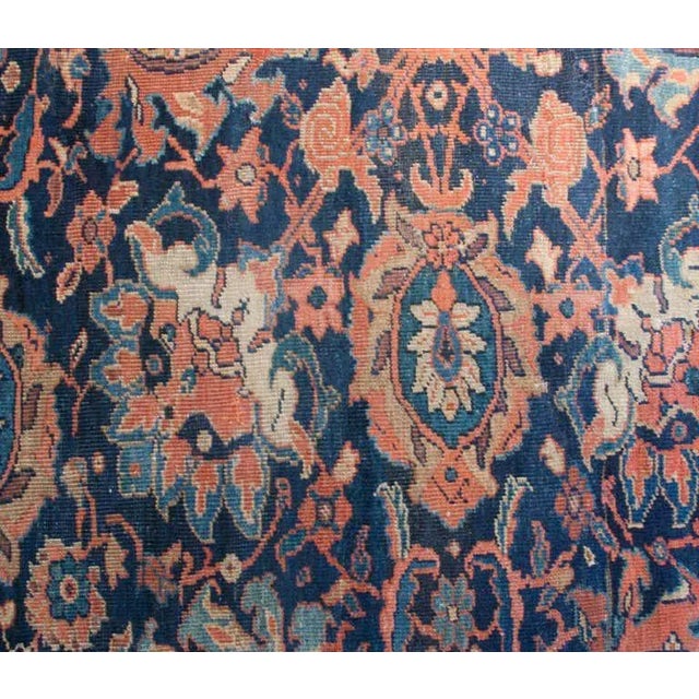 19th century Persian Sultanabad carpet with a bold all-over floral pattern on an indigo background, surrounded by a tree-...