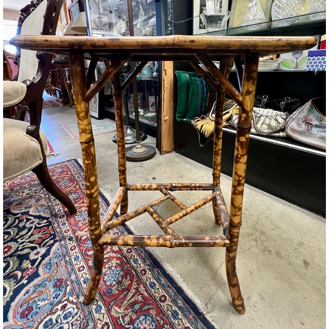 Victorian Rattan side table with beautiful Asian inspired painting on top and distinctive geometric lower shelf. 22"w x...