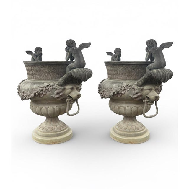 These monumental urns are masterfully cast with a rich, multi-toned patina that highlights their intricate architectural...