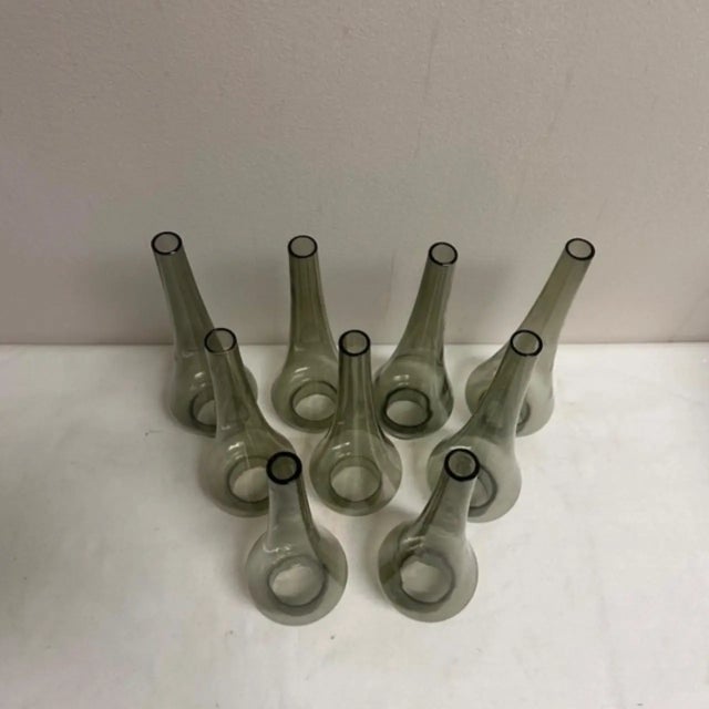 A set of nine smoked glass tapered hurricane style chandelier shades that stand.9.5" H x 1.5"D at top x 3"D opening at...