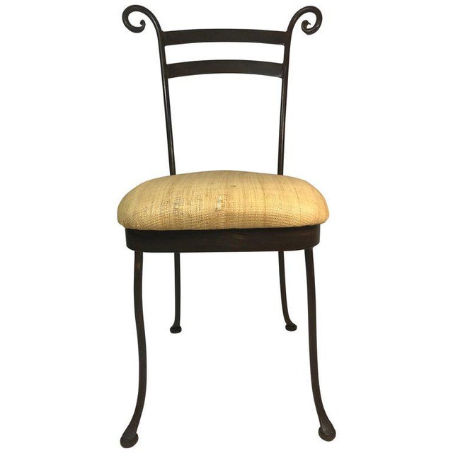 Stylistic set of four vintage handcrafted cafe side chairs. Black iron with a curlicue scroll ending top rail-splay leg...
