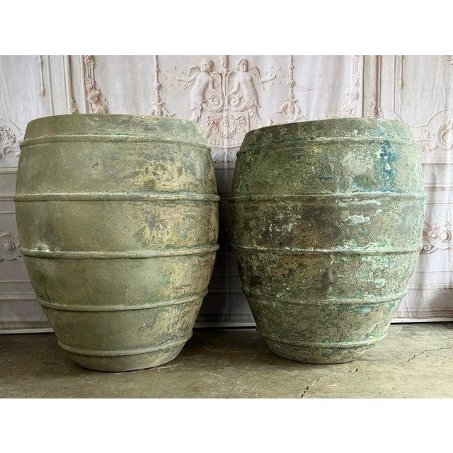 A magnificent pair of colossal Mediterranean-style barrel-form olive jars, offering monumental scale and an extraordinary...